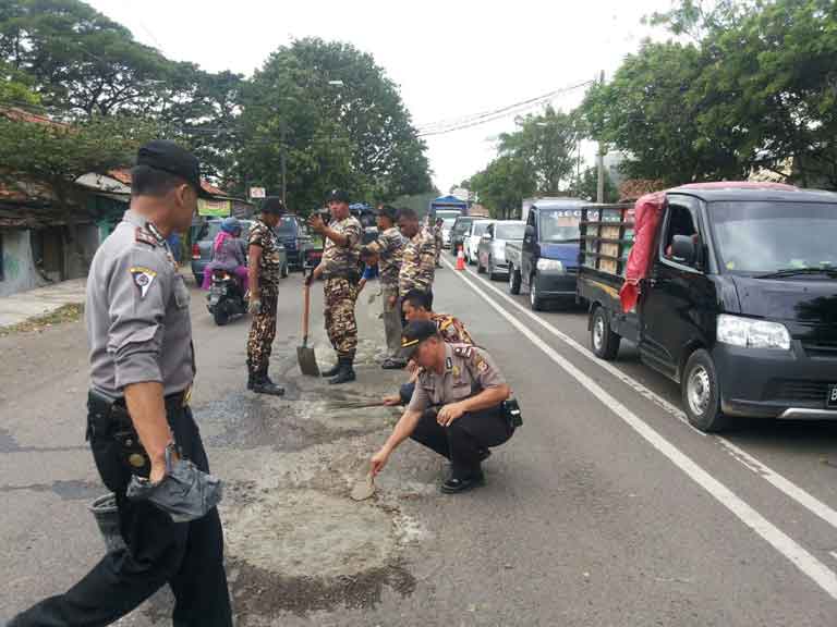 Polisi dan GM FKPPI Tambal Lubang Jalan